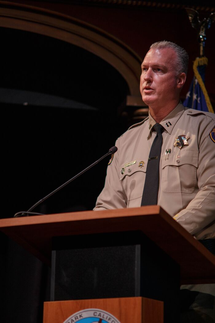Uniformed sheriff’s captain speaking at a podium