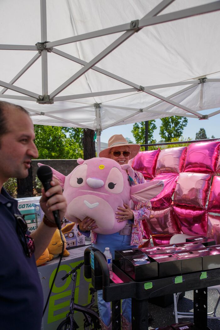 Emcee with a microphone at an outdoor community fair booth