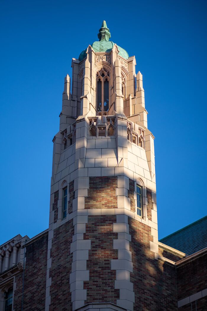 Gothic brick and stone tower against a deep blue sky